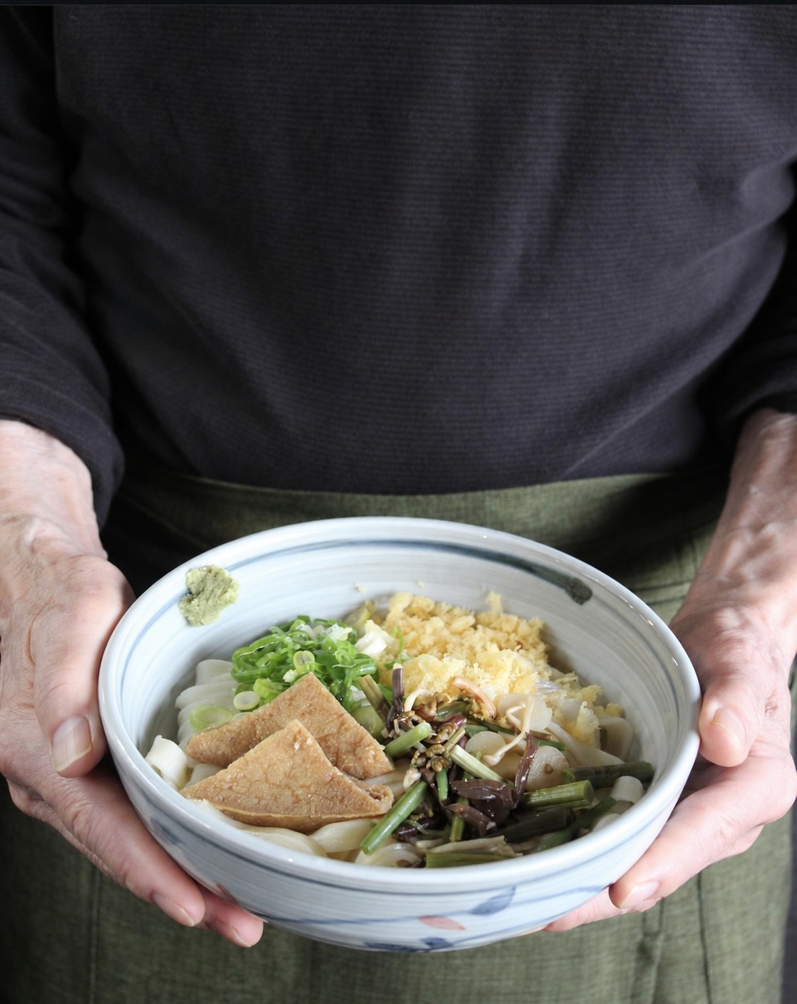 角屋の料理を両手で差し出す様子